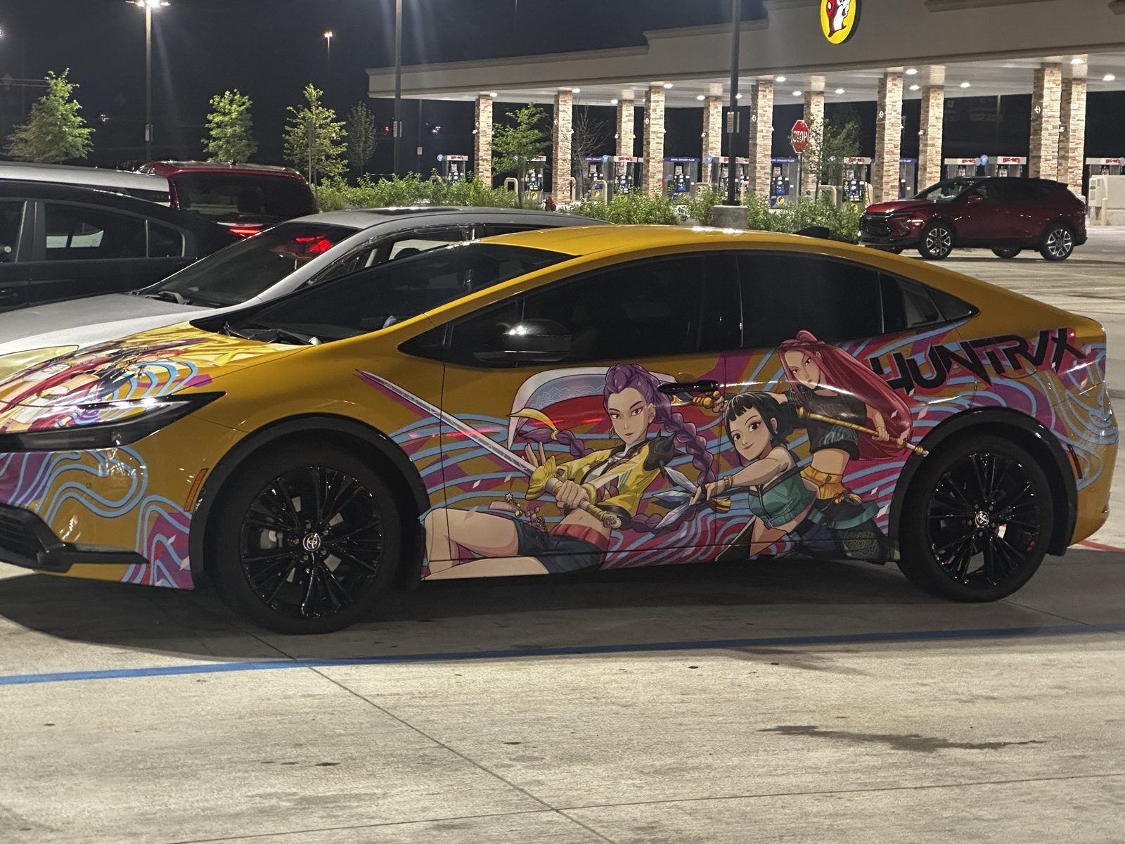 Toyota Prius with a colorful anime wrap parked under the lights at the Huber Heights Buc-ee’s